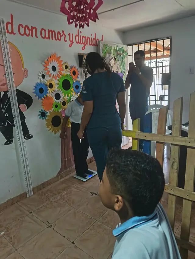 Medición de estatura de un niño con el apoyo del banco de alimentos