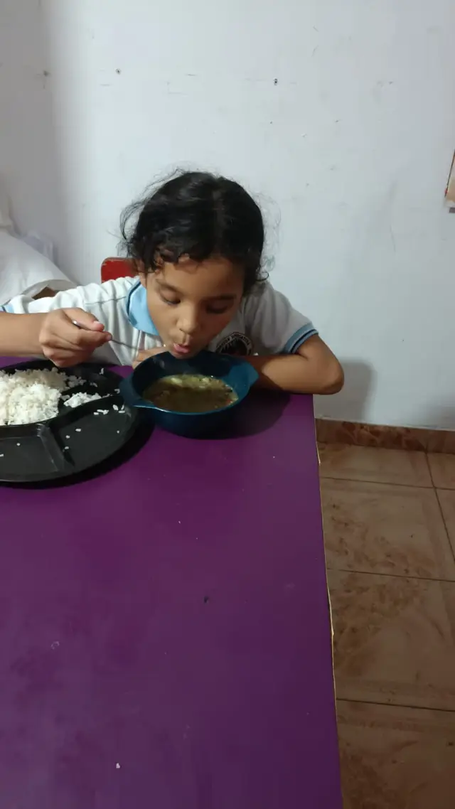 Niño comiendo arroz con pollo