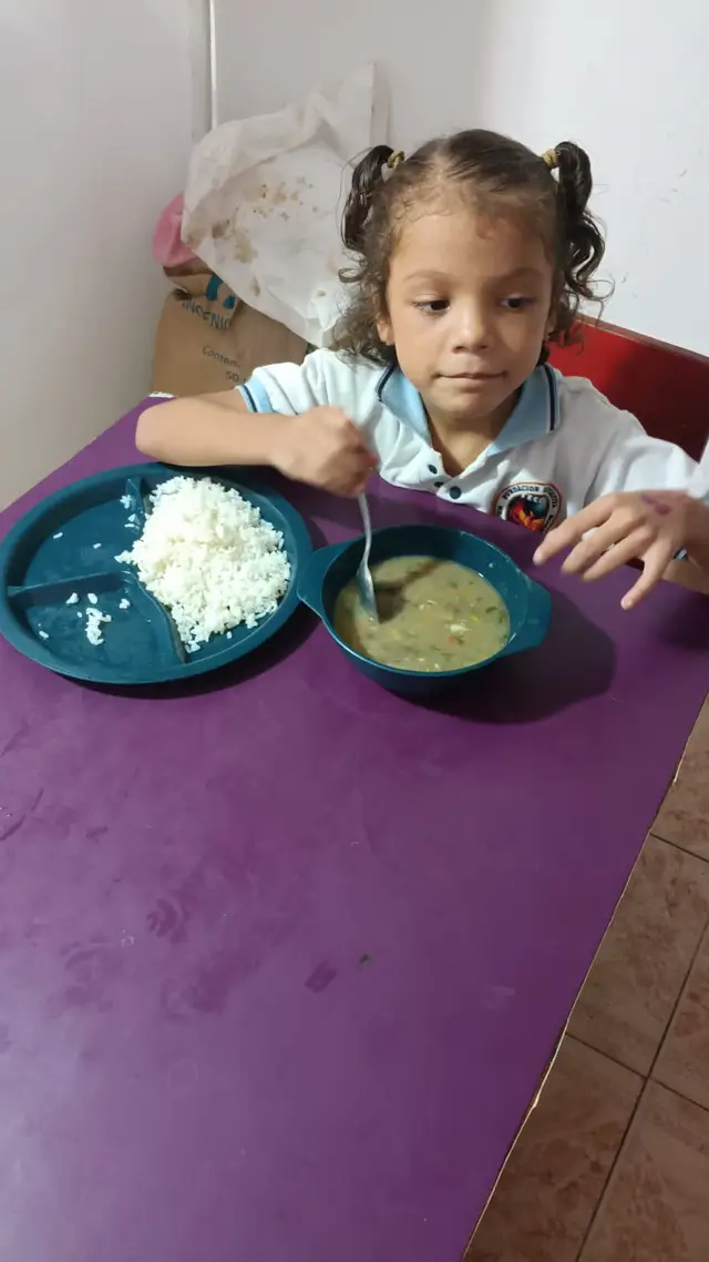 Niña comiendo sopa de costilla