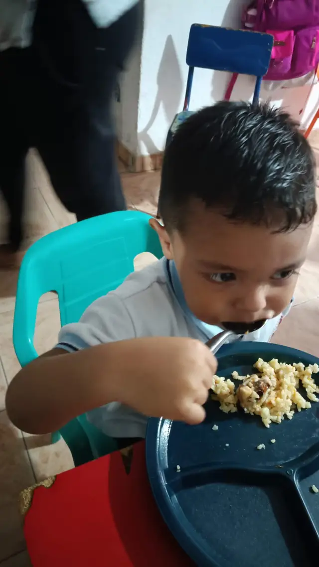 Niño pequeño comiendo en su silla
