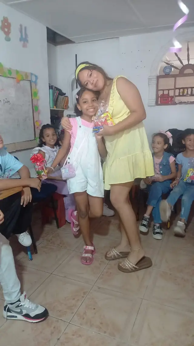 Miembro del equipo abrazando a una niña en la celebración